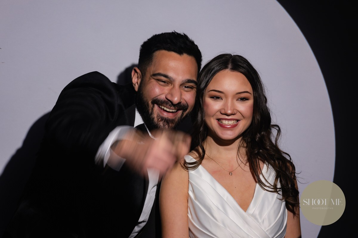 A couple enjoying their wedding photobooth together